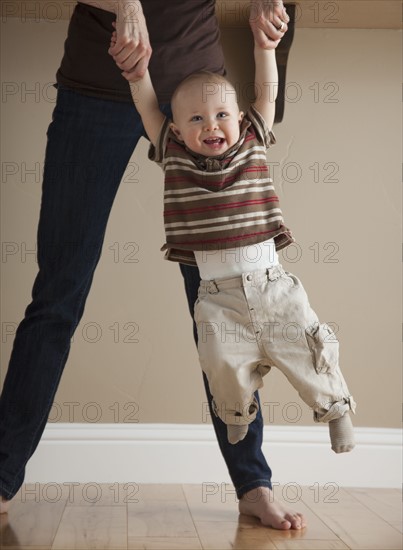 Mother swinging toddler. Photographer: Mike Kemp