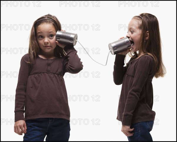 Girls playing with tin can phones. Photographer: Mike Kemp