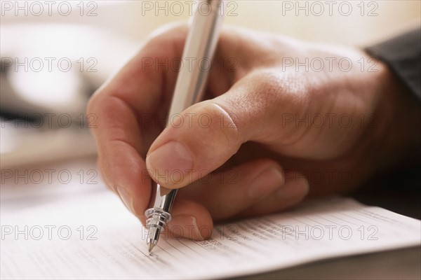 Man writing with a pen. Photographer: Rob Lewine