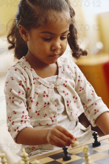 Young girl playing chess. Photographer: Rob Lewine