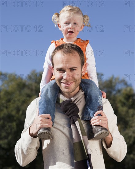 Father holding daughter on his shoulders. Photographer: Mike Kemp