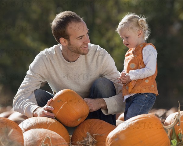 Father and daughter in pumpkin patch. Photographer: Mike Kemp