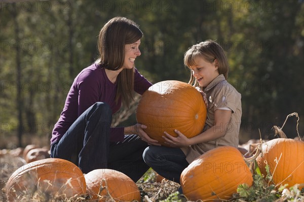 Mother and daughter in pumpkin patch. Photographer: Mike Kemp