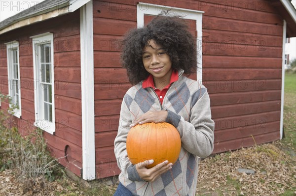 Woman holding a pumpkin. Photographer: Pauline St.Denis