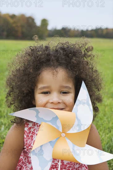 Young girl holding toy windmill. Photographer: Pauline St.Denis