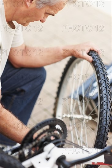 Man repairing bicycle. Photographer: momentimages