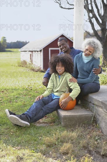 Family sitting on porch. Photographer: Pauline St.Denis