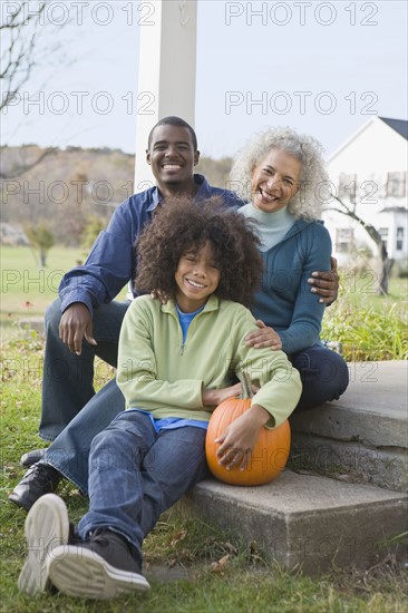 Family sitting on porch. Photographer: Pauline St.Denis