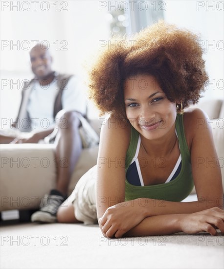 Couple relaxing in living room. Photographer: momentimages