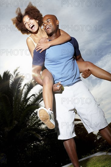 Man carrying woman on his back. Photographer: momentimages