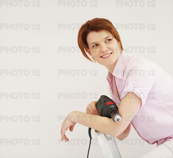 Woman holding a drill. Photographer: momentimages