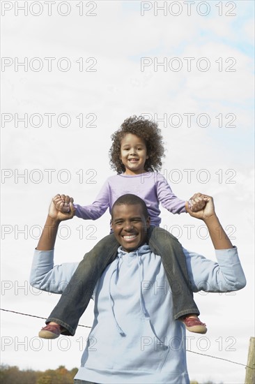 Man carrying daughter on his shoulders. Photographer: Pauline St.Denis