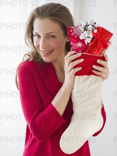 Woman holding Christmas stocking.