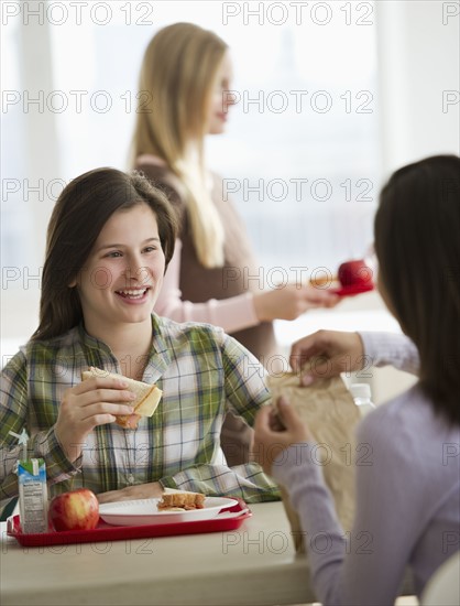 Friends eating in cafeteria.