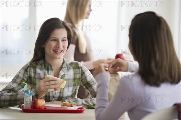 Friends eating in cafeteria.