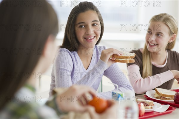 Friends eating in cafeteria.