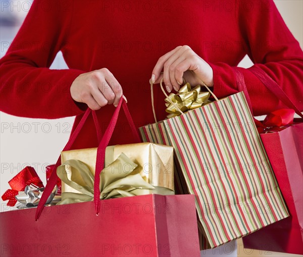 Woman holding bags of gifts.