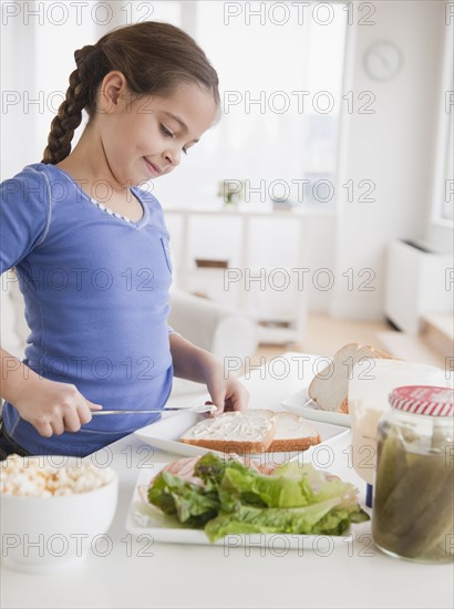 Young girl making sandwich. Photographer: Jamie Grill