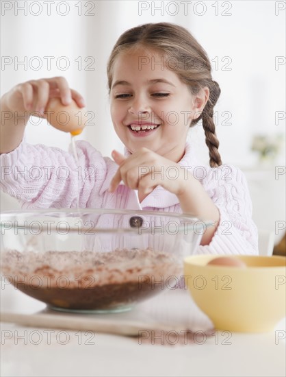 Young girl cracking egg. Photographer: Jamie Grill