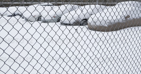 Parking lot behind chain link fence. Photographer: fotog