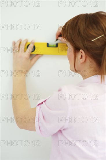 Woman using a level. Photographer: momentimages