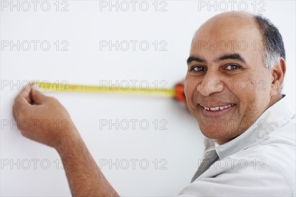 Man measuring wall. Photographer: momentimages