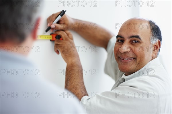 Man measuring wall. Photographer: momentimages