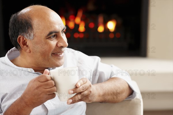 Man relaxing in living room. Photographer: momentimages
