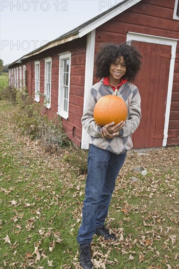 Woman holding a pumpkin. Photographer: Pauline St.Denis