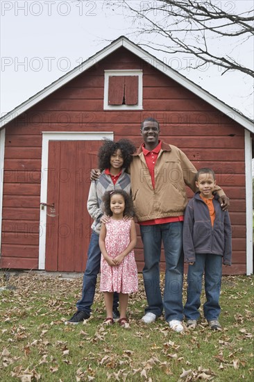 Family standing in front of barn. Photographer: Pauline St.Denis