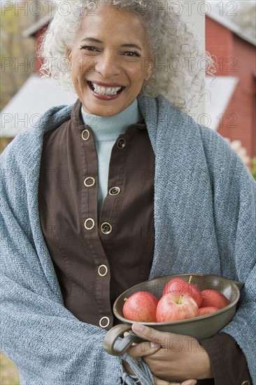 Woman holding bowl of apples. Photographer: Pauline St.Denis