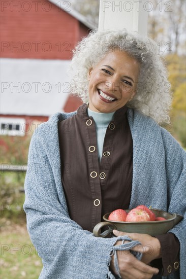 Woman holding bowl of apples. Photographer: Pauline St.Denis