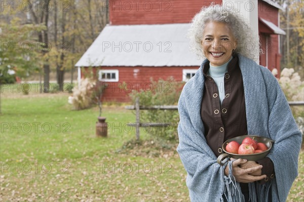 Woman holding bowl of apples. Photographer: Pauline St.Denis