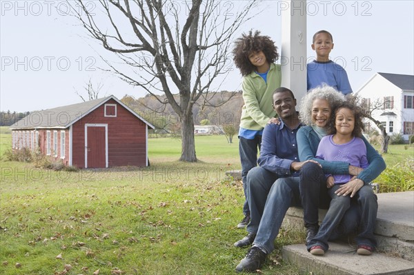 Family sitting on porch. Photographer: Pauline St.Denis