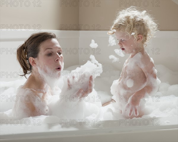 Mother and child having bubble bath. Photographer: Mike Kemp