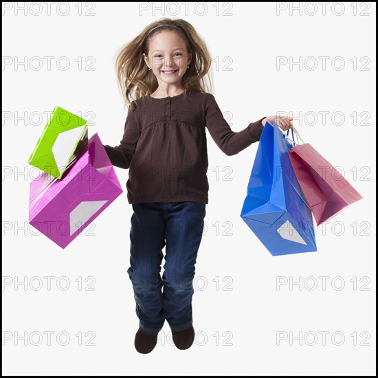 Young girl holding shopping bags. Photographer: Mike Kemp