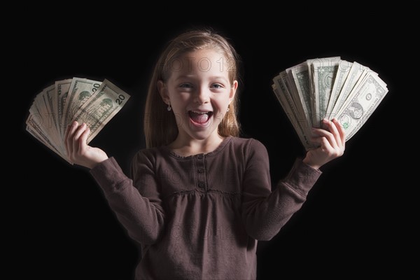 Young girl holding money. Photographer: Mike Kemp