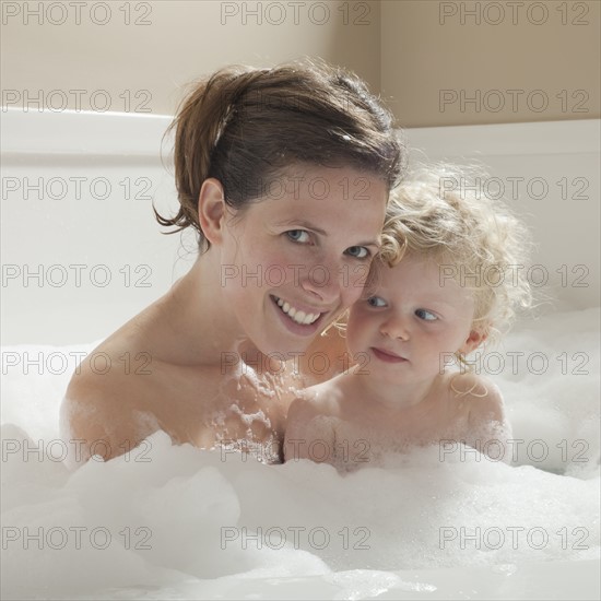 Mother and child having bubble bath. Photographer: Mike Kemp