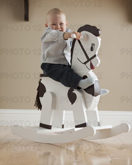Baby on rocking horse. Photographer: Mike Kemp