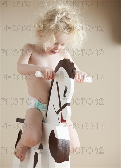 Toddler on rocking horse. Photographer: Mike Kemp