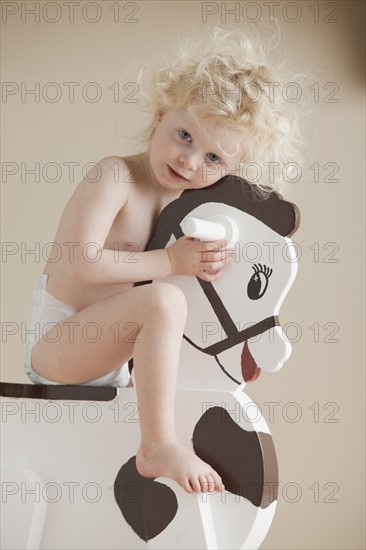 Toddler on rocking horse. Photographer: Mike Kemp