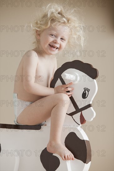 Toddler on rocking horse. Photographer: Mike Kemp