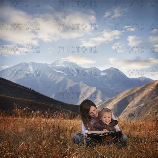 Mother and son reading outdoors. Photographer: Mike Kemp