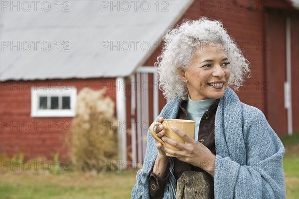 Woman holding mug outside. Photographer: Pauline St.Denis