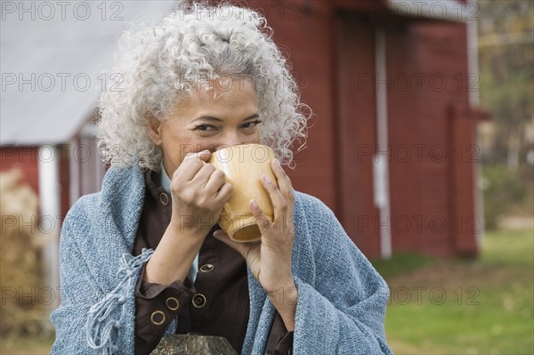 Woman drinking from mug. Photographer: Pauline St.Denis