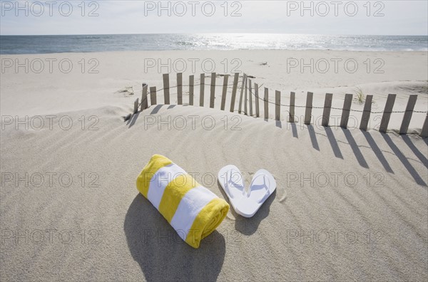 Towel and flip flops on the beach. Photographer: Chris Hackett