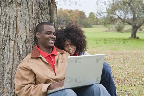 Couple looking at laptop outside. Photographer: Pauline St.Denis