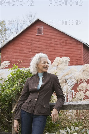 Woman leaning against fence. Photographer: Pauline St.Denis