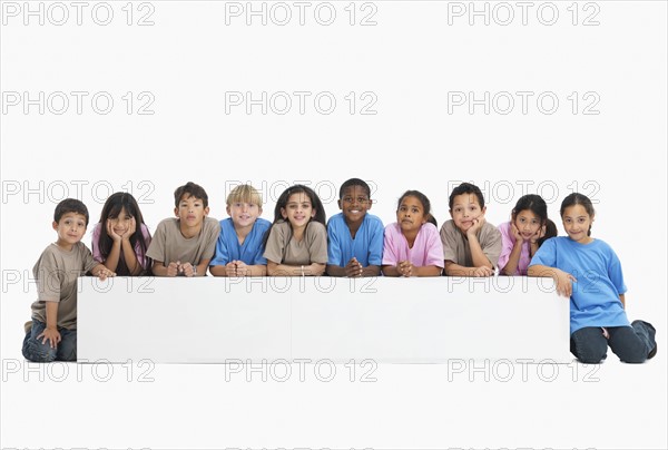 Children sitting in a row. Photographer: momentimages