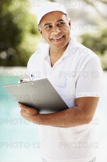 Tradesman writing on clipboard. Photographer: momentimages